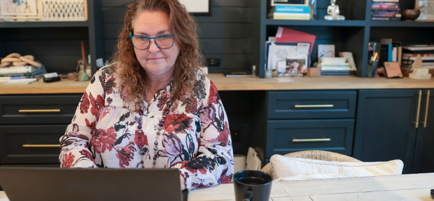 A female ADT Human Resources worker sits working at here desk.