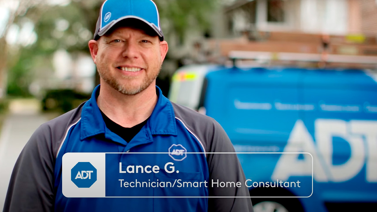 Lance G., an ADT technician/Smart Home Consultant, standing in front of an ADT van, smiling at the camera
