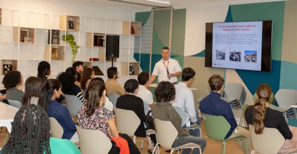 speaker presenting to a group of interns facing him in chairs